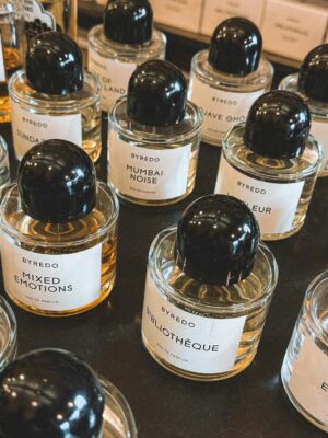 Close-up view of various Byredo perfumes with elegant labels arranged on a shelf.